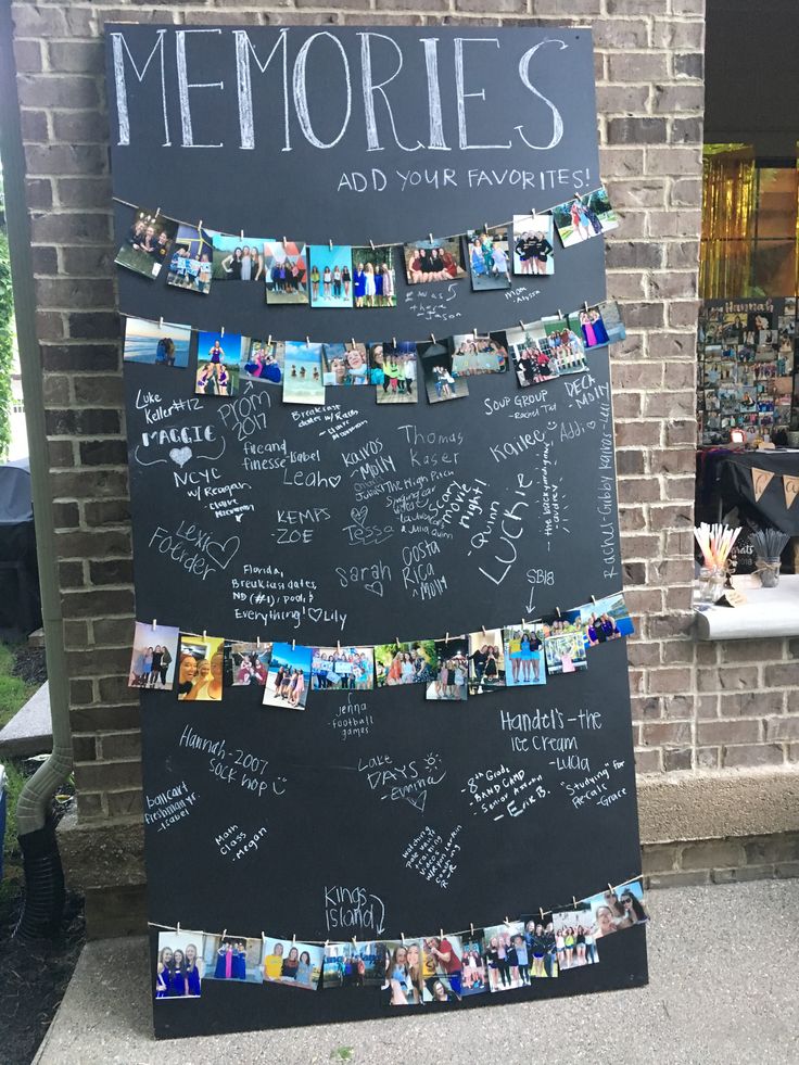 a blackboard with pictures and words written on it in front of a brick building