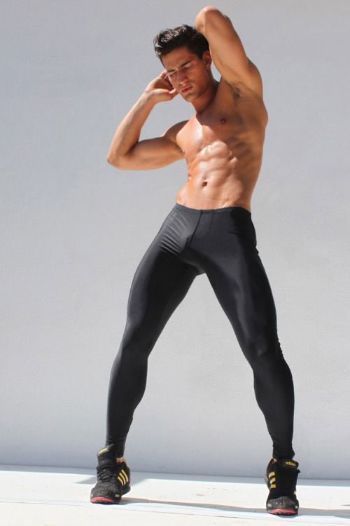 a shirtless man in black pants and no shirt is posing for the camera with his hands behind his head