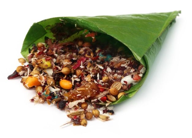 a green leaf filled with food on top of a white surface