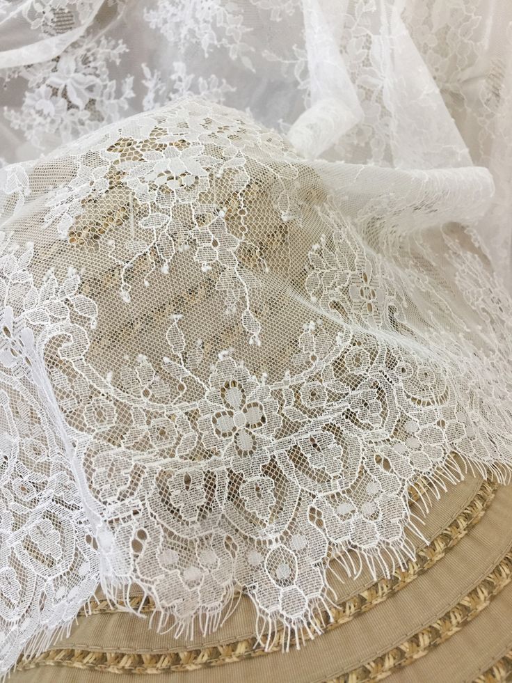 white lace with gold trims is laying on top of fabric