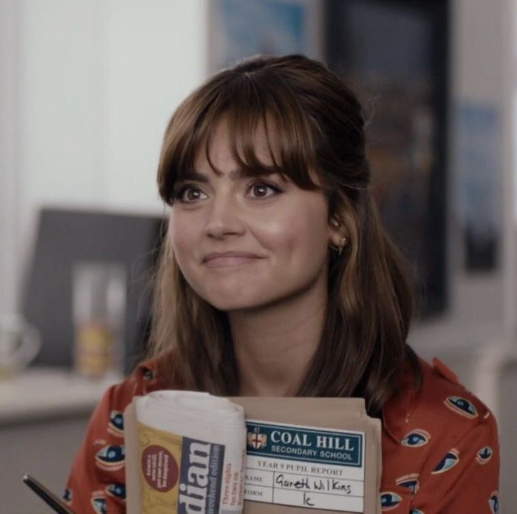 a woman is holding up a box of cereal