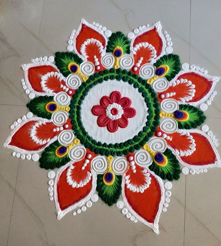 an intricately designed flower design on the floor in white and red colors with green leaves