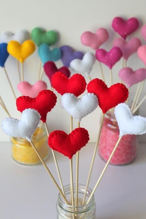 there are many heart shaped lollipops in the jar