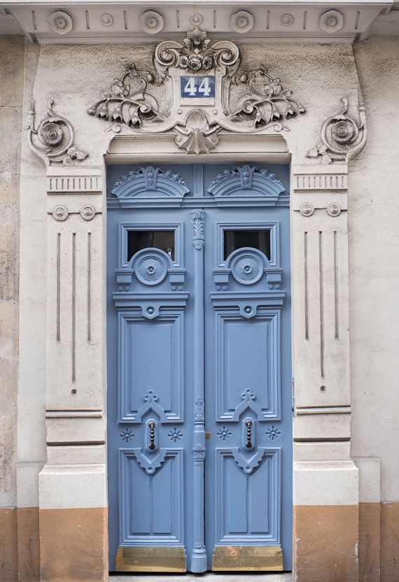 two blue doors are open in front of a building