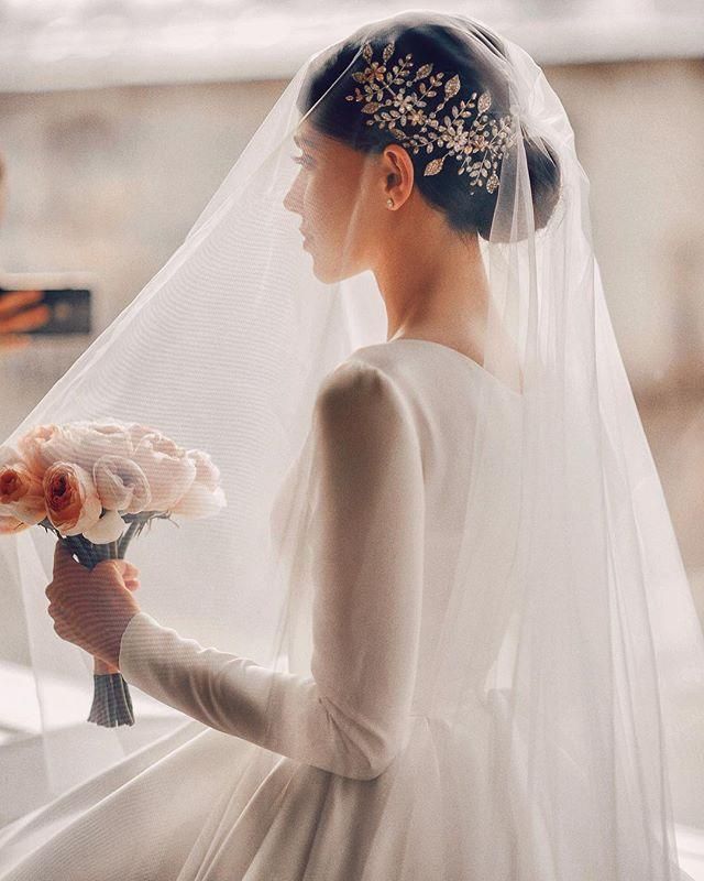 a woman wearing a veil holding a bouquet of flowers