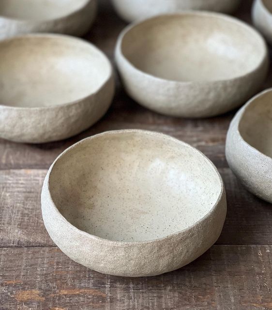 several white bowls sitting on top of a wooden table