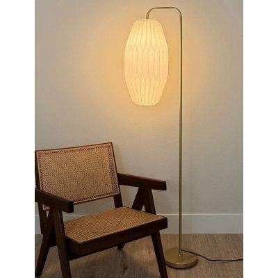 a lamp that is on top of a chair next to a wall with a light in it