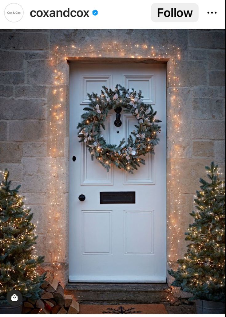 a white door decorated with christmas lights and a wreath