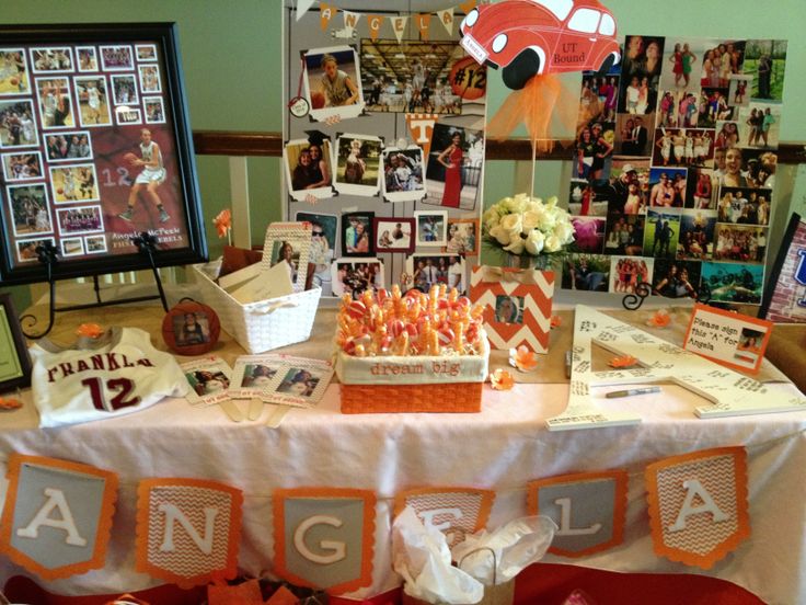 an orange and white table topped with pictures and candy bar wrapper decorations on top of it