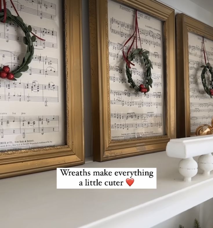 three framed music sheets with wreaths hanging on them