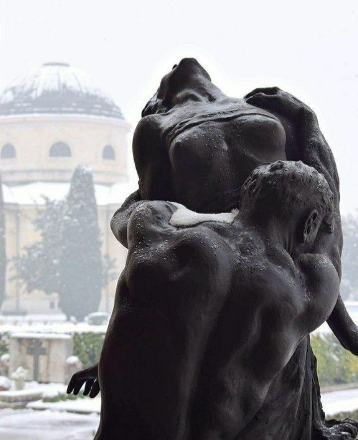 two statues sitting next to each other in the snow