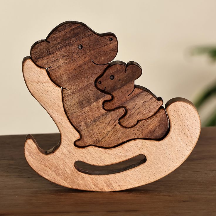 a wooden rocking toy with a mouse on it's back in the shape of a bear