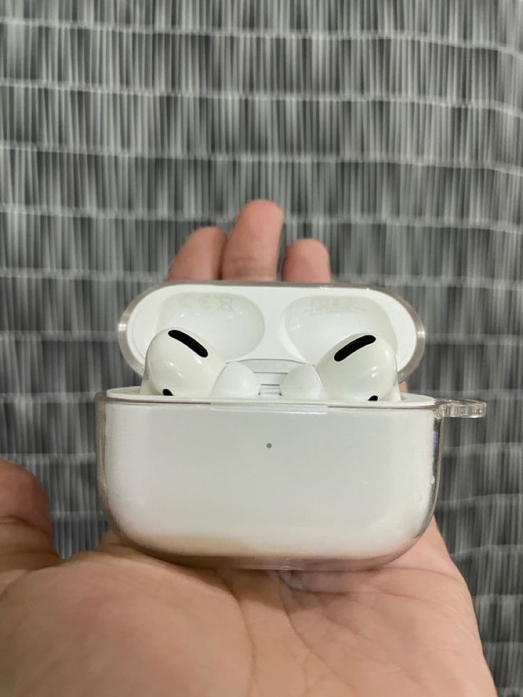 someone is holding an airpods in their hand