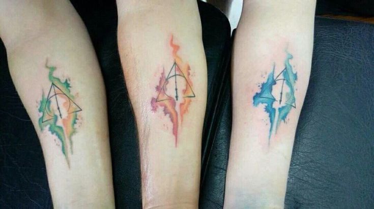 two people with matching tattoos on their arms and legs, both have watercolor splashes