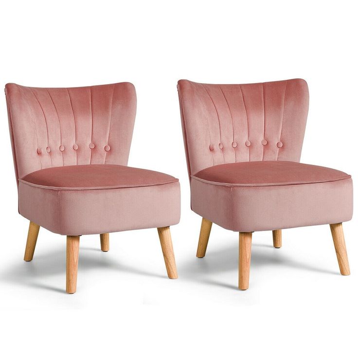 two pink velvet chairs with wooden legs and buttons on the back, one is upholstered