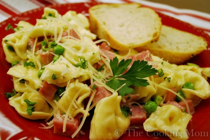 a red plate topped with pasta and ham