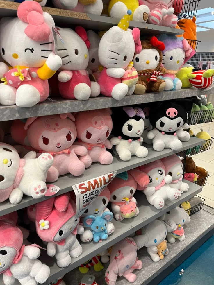 hello kitty stuffed animals are on display in a store aisle, with other plush toys behind them