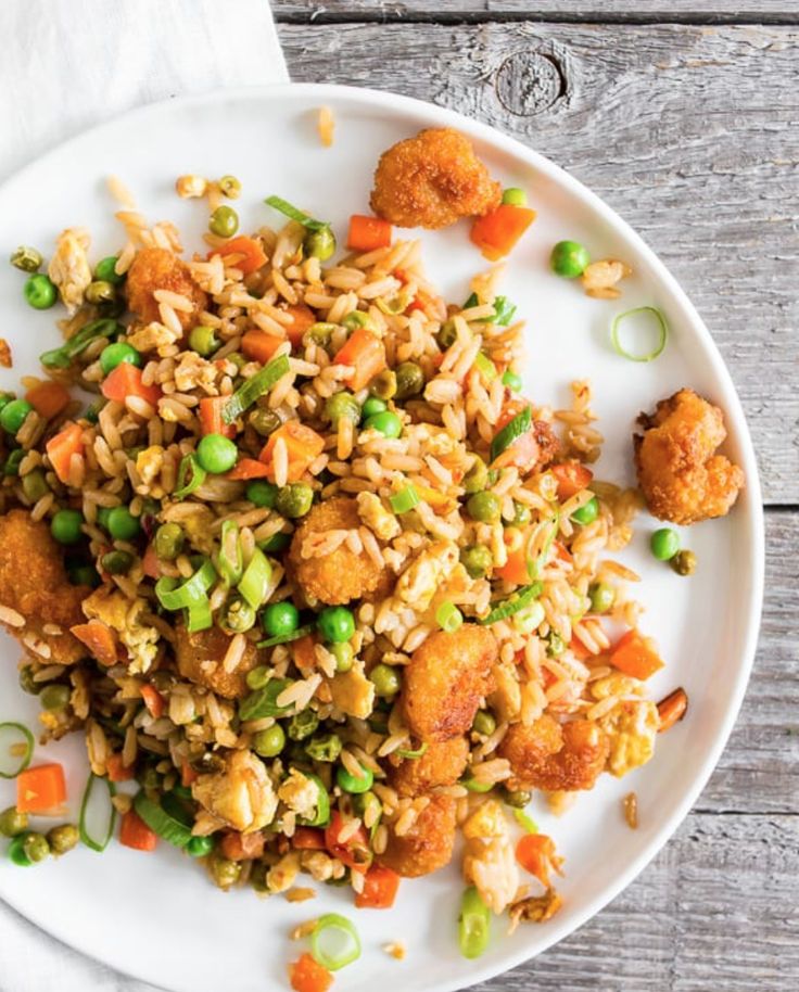 a white plate topped with fried rice and vegetables