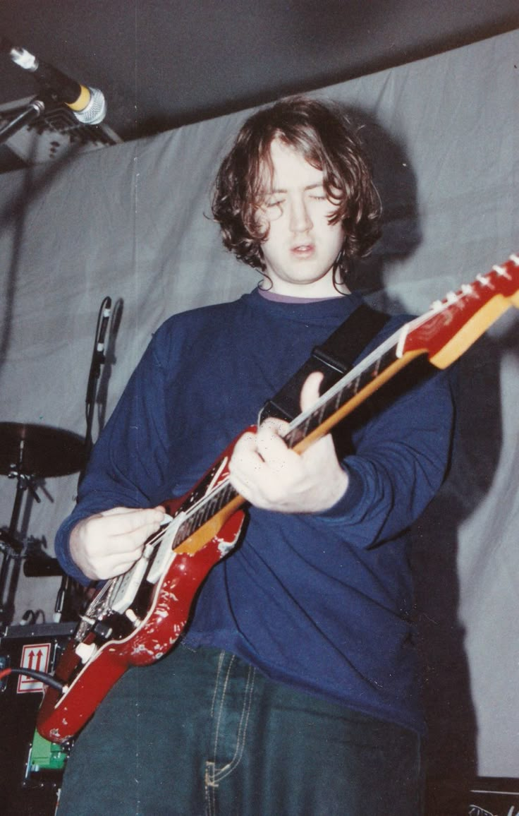 a young man is playing an electric guitar