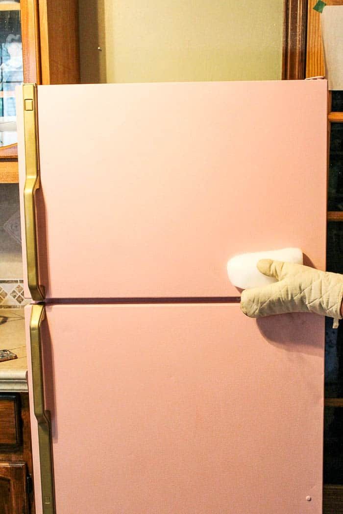 a pink refrigerator freezer sitting inside of a kitchen