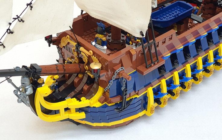 a lego model of a pirate ship with sails and rigs on the front, sitting on a white surface