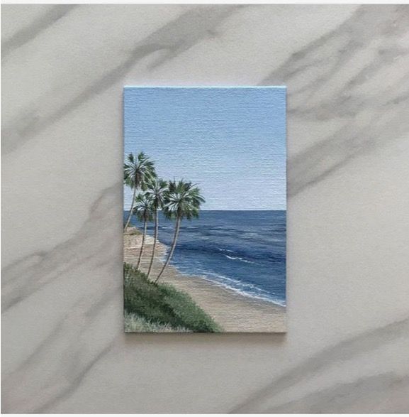 a card with palm trees on the beach and water in the ocean behind it is a white marble background