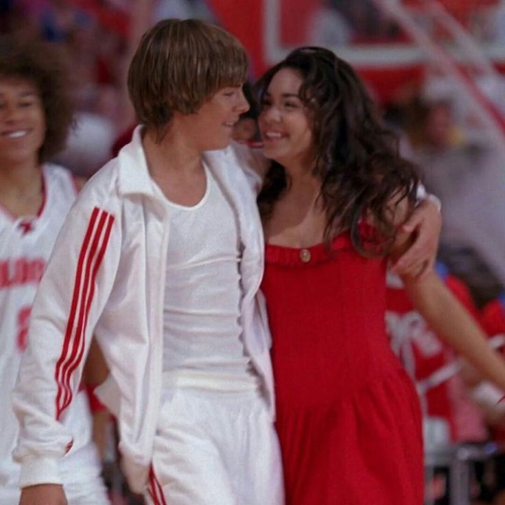 two people standing next to each other on a basketball court