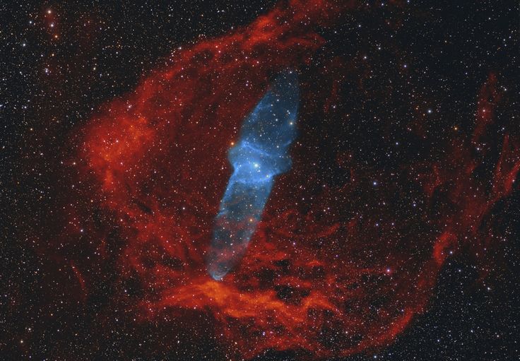 the large blue object is in the middle of the space, surrounded by red and blue stars