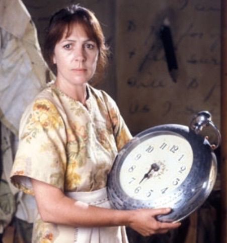 a woman holding an old clock in her hands