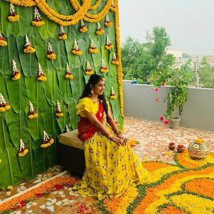 a woman sitting on a bench in front of a flower display