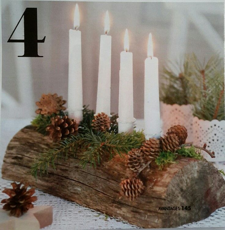 a wooden log with candles and pine cones on it