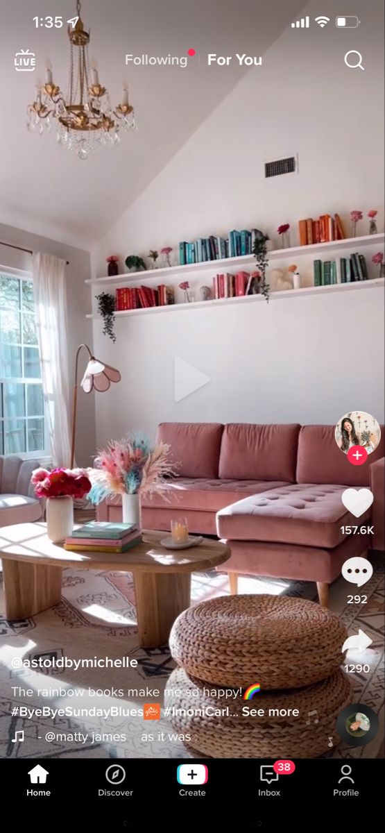 a living room filled with furniture and a chandelier hanging from the skylight