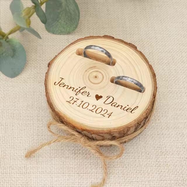 a wooden ring holder with two rings on it and the words, wedding date engraved on it