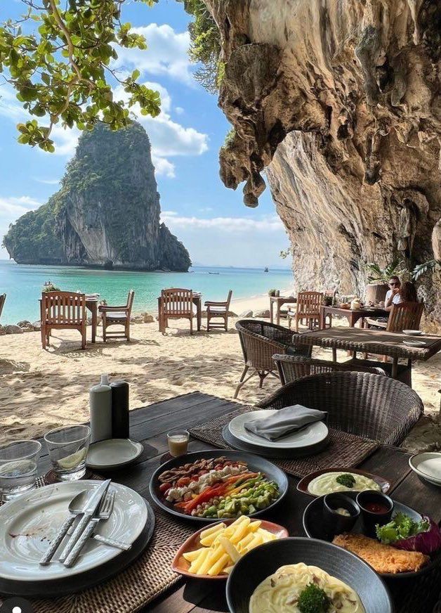 an outdoor dining area overlooking the beach and ocean