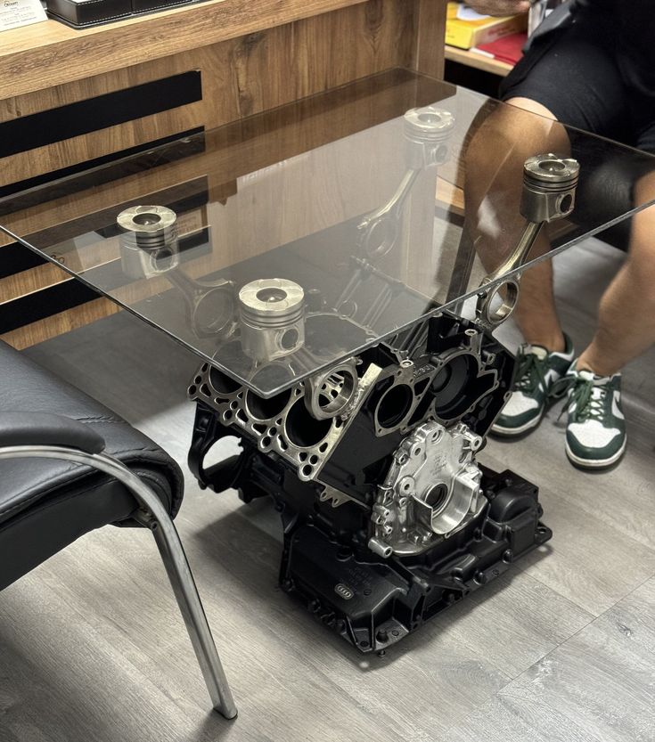 a man sitting at a table with an engine on it