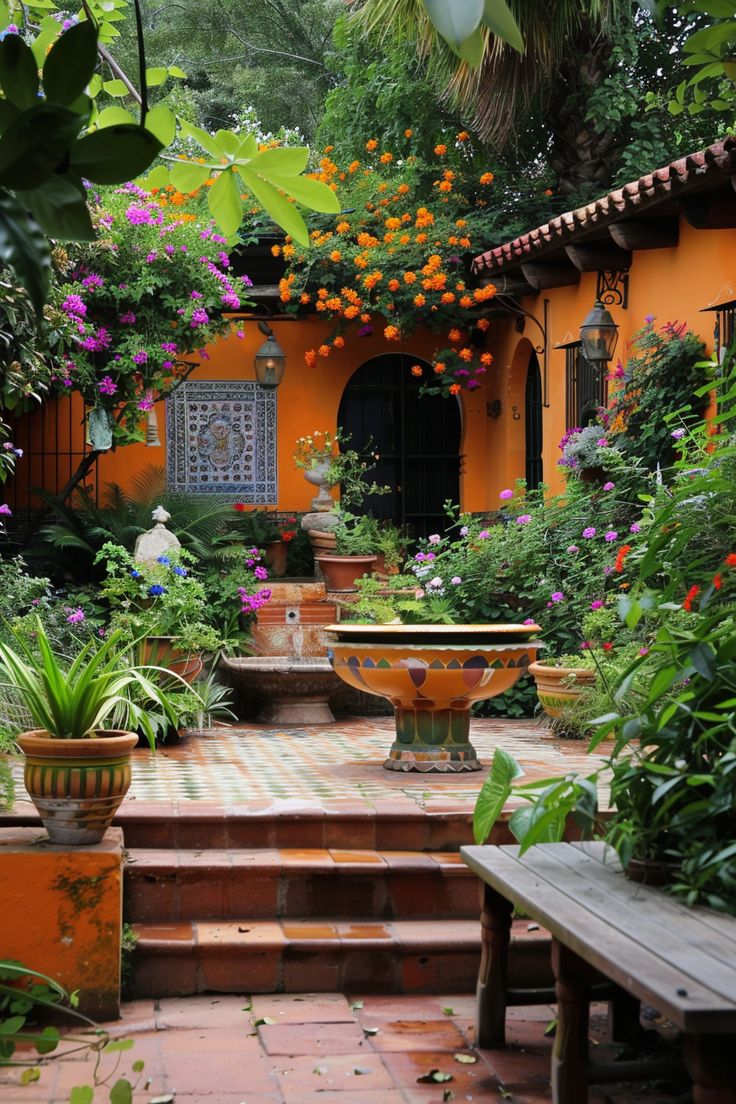 an orange walled courtyard with potted plants and flowers on the steps leading up to it