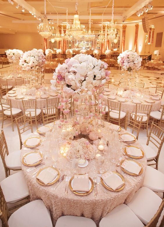 the tables are set with white and pink flowers