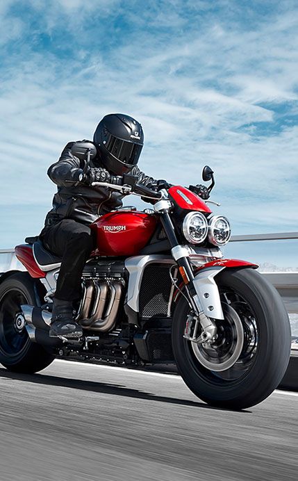 a man riding on the back of a red motorcycle