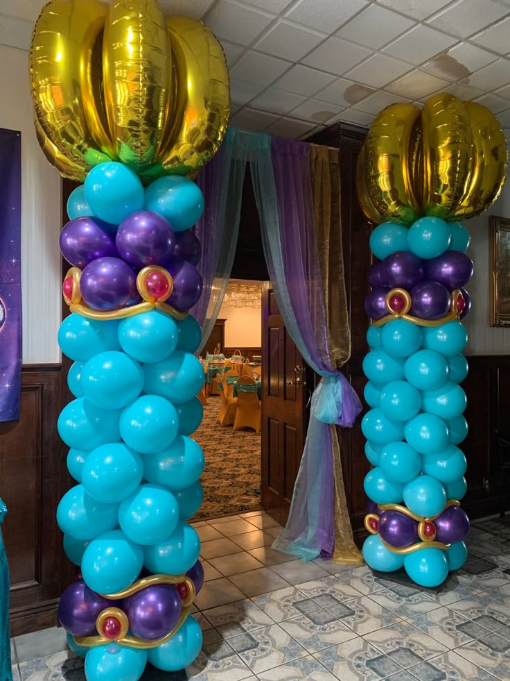 balloon columns are decorated with blue, purple and gold balloons