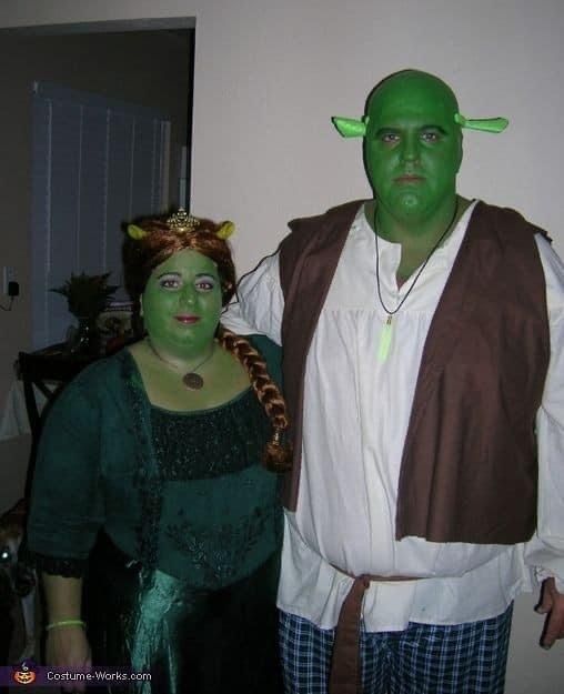 two people dressed in costumes standing next to each other with green makeup on their faces