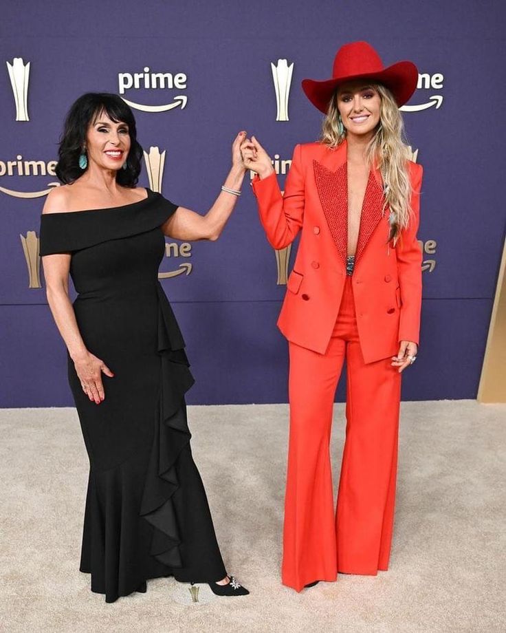 two women standing next to each other on a carpet