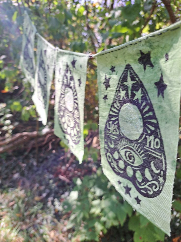 some green and black paper hanging from a tree