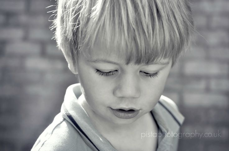 a young boy with his eyes closed looking down