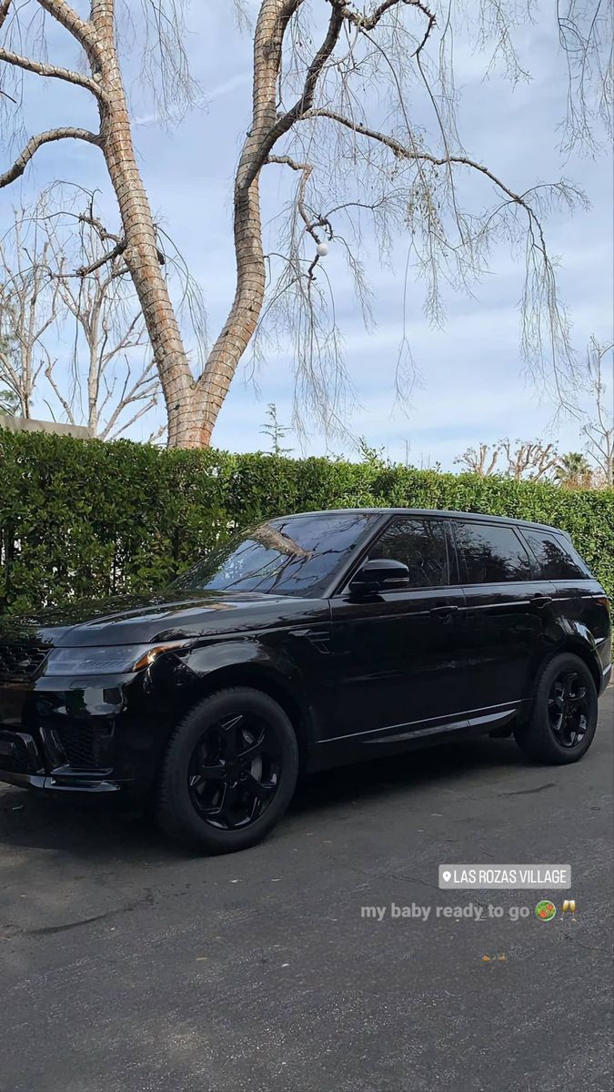 a black suv parked in front of a tree with the caption my baby is back from getting pretty