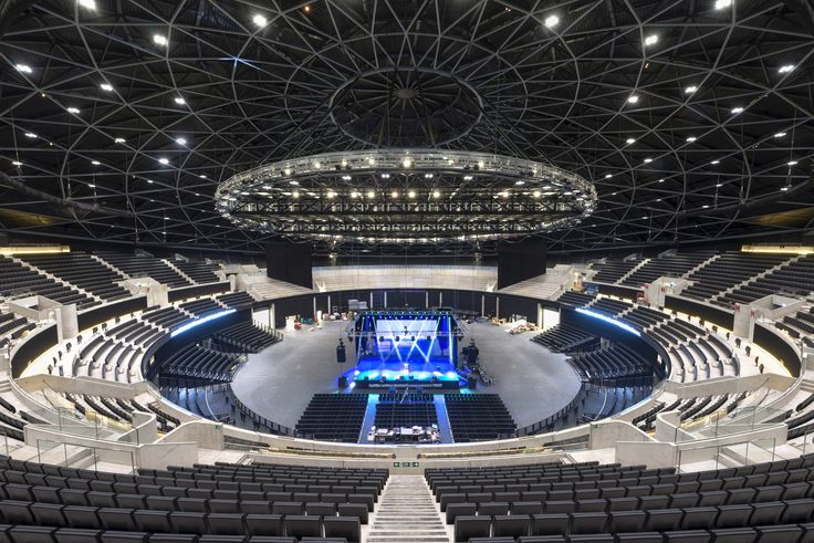 an empty auditorium filled with lots of seats and lights on the ceiling is lit up