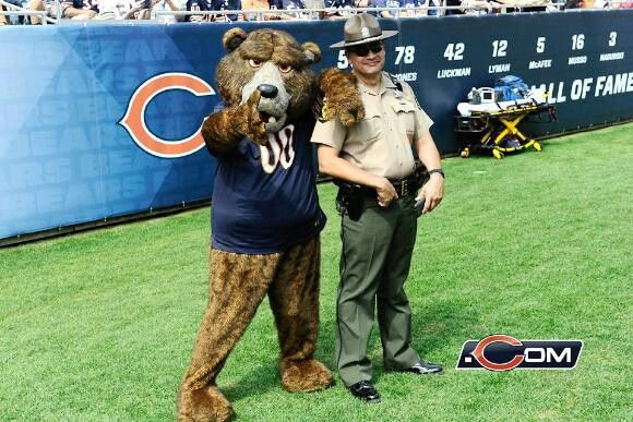 a man in a bear costume standing next to a mascot