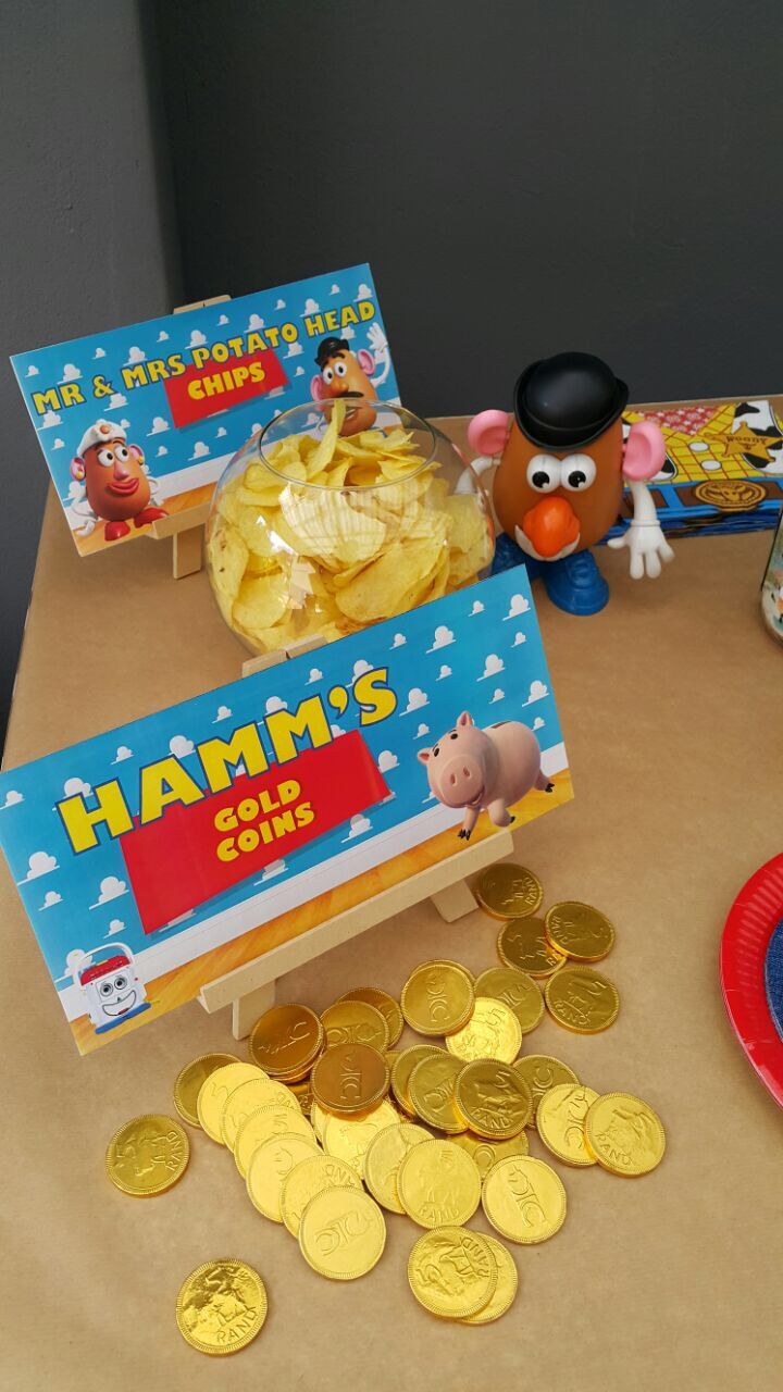 a table topped with lots of gold coins and little red pig book on top of it