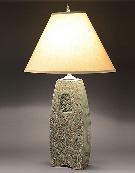 a ceramic lamp with a white shade on it's base and a light bulb in the shape of a bird