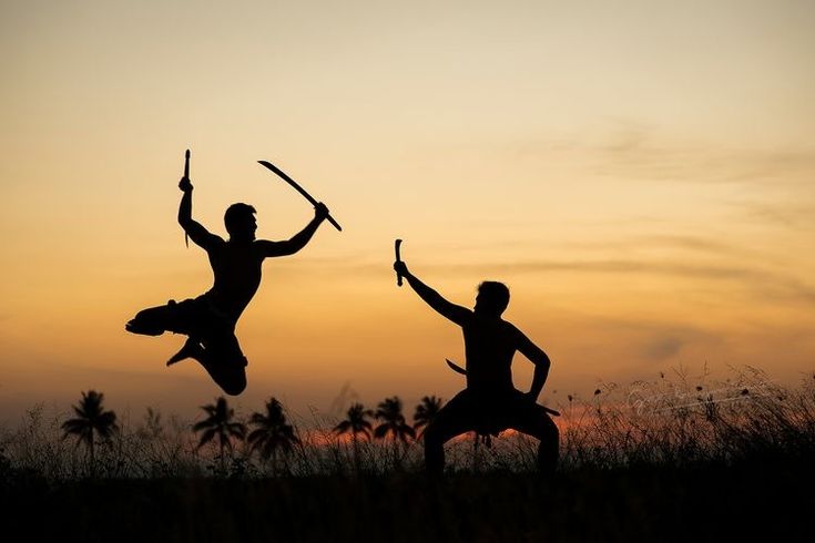 two people jumping in the air with their arms up