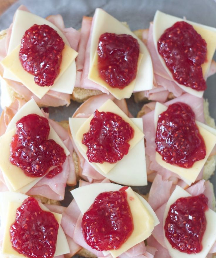 small appetizers with cheese, ham and jam on them